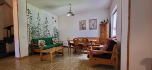 un soggiorno con tavolo da pranzo e sedie di Villino Fonte Fracassi a Pescasseroli