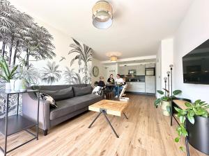 een woonkamer met mensen aan een tafel bij Tropical Apartment in Koblenz