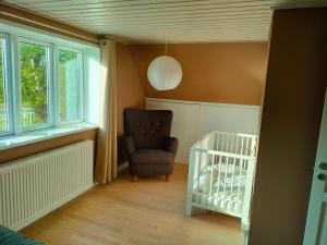 - une chambre bébé avec une chaise haute et un lit bébé dans l'établissement Nygaard Guesthouse, à Hjørring
