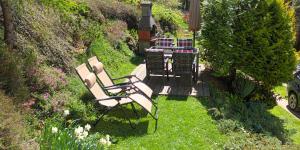 a group of chairs and a table in a garden at Holiday Home Forest Peace, Lavrovec in Hlevni Vrh