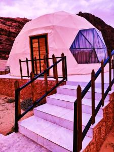 a yurt in the desert with stairs leading to it at desert Rose & bubble tent in Wadi Rum