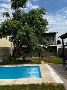 a blue swimming pool in front of a house at La Casita Yogui - MONOAMBIENTE 2 in Santa Rosa de Calamuchita