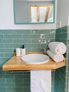 bagno con lavandino, specchio e asciugamani di minicasita tipica a Zuheros