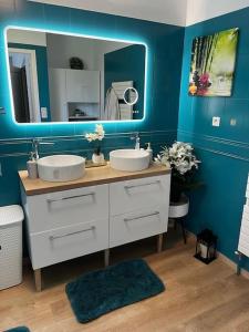 a blue bathroom with two sinks and a mirror at Grande maison de 152 m² /6 pers. in Salles +7 photos