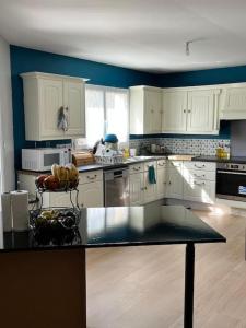 a kitchen with white cabinets and a black counter top at Grande maison de 152 m² /6 pers. in Salles