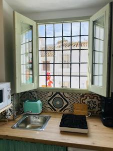 un bancone della cucina con lavandino e due finestre di minicasita tipica a Zuheros