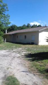 a white building in a field next to a road at Grande maison de 152 m² /6 pers. in Salles