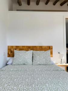 una camera con un grande letto con testiera in legno di minicasita tipica a Zuheros