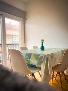 ein Tisch mit Stühlen und einer Vase darauf in der Unterkunft Vivienda de uso turístico Piso de Castro in Sardiñeiro