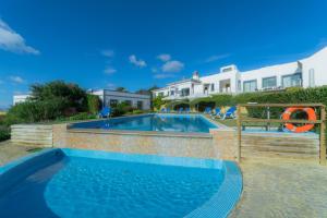 a swimming pool in front of a house at Casas de Campo em Estoi by Garvetur in Estói
