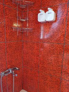 La salle de bains est pourvue d'un rideau de douche rouge et de 2 toilettes. dans l'établissement LittleLoft Ioannina, à Ioannina