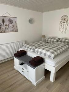 a bedroom with a white bed with a checkered blanket at Ferienwohnung am Waldrand in Tharandt