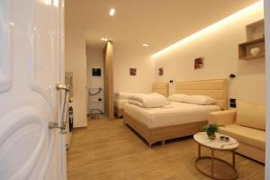 a hotel room with two beds and a couch at Reni Risi Deluxe Studio in Sarandë +4 photos