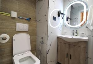 a bathroom with a white toilet and a sink at Reni Risi Deluxe Studio in Sarandë