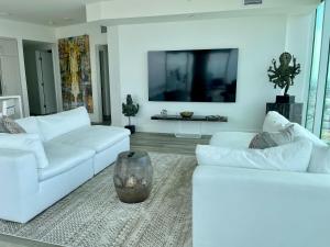 a living room with two white couches and a tv at Massive Penthouse Overlooking All of San Diego in San Diego