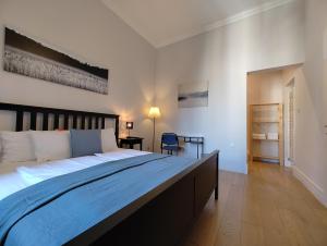 Apartment Theatrum في زغرب: غرفة نوم فيها سرير كبير وكرسي فيها