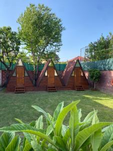 een set van vier houten hutten in een tuin bij The Hood - Shkodra Backpackers Hostel in Shkodër