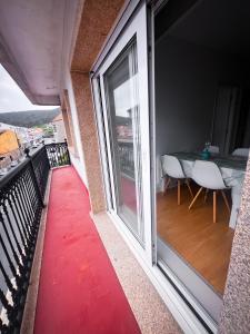 ein Balkon mit einem roten Teppich und einem Tisch in der Unterkunft Vivienda de uso turístico Piso de Castro in Sardiñeiro + 15 Fotos