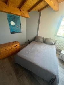 にあるVacances à la ferme en Ardècheの木製の天井が特徴のベッドルーム1室(ベッド1台付)