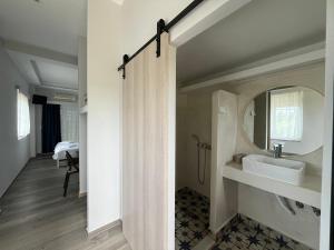 uma casa de banho com um lavatório e um espelho em Apartments Katoji em Chrani
