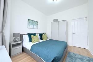 a white bedroom with a bed and a white closet at Bright & Large 3 Bed Flat in London in London