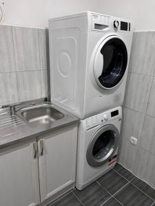 uma máquina de lavar roupa e um lavatório na cozinha em Apartments Divanhana em Kiseljak