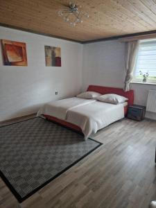 een slaapkamer met een groot bed met een rood hoofdeinde bij Ferienwonung in Pullenreuth