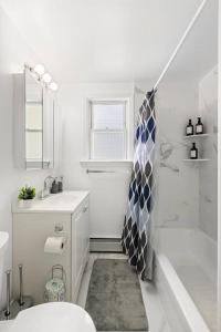 a bathroom with a tub and a shower and a sink at Comfy Cozy retreat - NYC & NWK w free parking in Bayonne