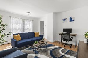 a living room with a blue couch and a desk at Comfy Cozy retreat - NYC & NWK w free parking in Bayonne