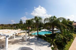 a view of the pool at a resort with palm trees at L' Arcobaleno Resort in Capo Vaticano