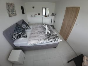 Un dormitorio con una cama con almohadas de cebra. en APARTMÁNY I&V Adults only, en Plzeň