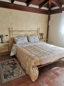 een groot bed in een slaapkamer met 2 lampen bij Villa Bigio in Assisi