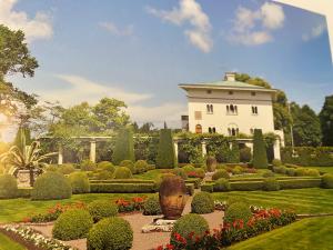a garden with a large white house in the background at Idyllic accommodation in the middle of Öland in Färjestaden