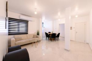 een woonkamer met een bank en een tafel met stoelen bij king david in Netanya