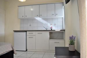 eine Küche mit weißen Schränken und einer Spüle in der Unterkunft Fotini's Studios 1 in Toroni + 42 Fotos