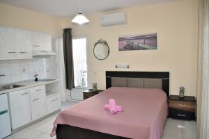 ein Schlafzimmer mit einer rosa Schleife auf einem Bett in der Unterkunft Fotini's Studios 1 in Toroni