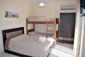 a bedroom with two bunk beds and a cabinet at Fotini's Studios 1 in Toroni