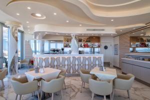 a restaurant with tables and chairs and a bar at Hotel La Margherita & SPA in Alghero