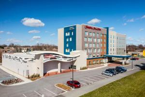 ein Hotel mit einem Parkplatz vor einem Gebäude in der Unterkunft Hampton Inn & Suites Indianapolis West Speedway in Indianapolis