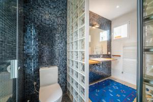 een badkamer met toilet en douche met blauwe tegels bij Villa Cana Chana in Santa Gertrudis de Fruitera +18 foto's