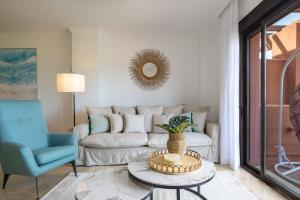 a living room with a couch and a table at Increíble y Moderno apartamento Duplex con piscinas y preciosas vistas in Estepona