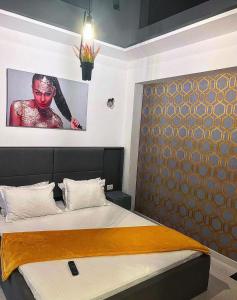 a bedroom with a bed with a picture on the wall at Azul Sunrise in Mamaia Sat/Năvodari