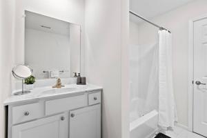 a white bathroom with a sink and a mirror at Home Sweet Home - near NWK & NYC w/free parking in Newark +19 photos
