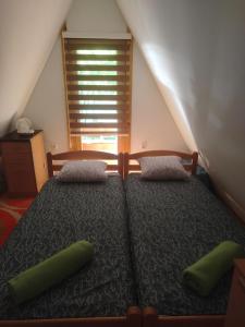 um quarto com uma cama com duas almofadas verdes em Vikendica Raj em Bihać