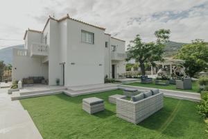 a white house with a yard with green grass at Le Jardin apartments in Kámpos