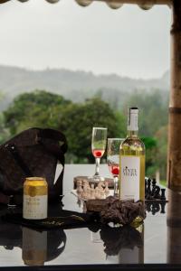 Vibras Eco Hotel في بوبايان: زجاجة من النبيذ وكأسين على الطاولة