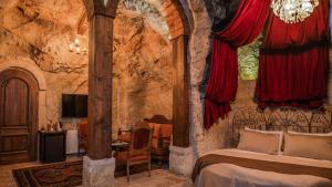 a bedroom with a bed in a stone room at Yeşil Konak Cave Hotel in Ürgüp