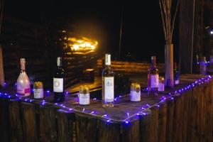 a group of bottles of wine on a wooden fence with lights at Vibras Eco Hotel in Popayan
