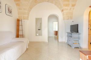 a living room with a bed and a tv at Villa a Serranova, Torre Guaceto in Carovigno