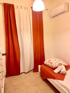 una camera con tenda rossa e letto di Marisia Apartment II a Città di Zante